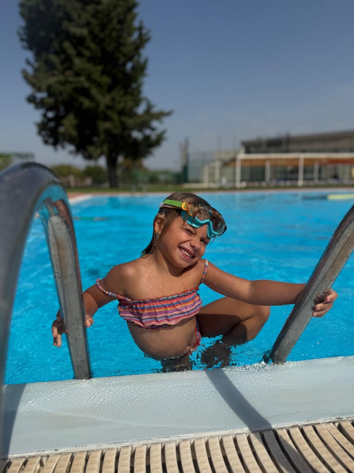 Nena sortint de la piscina per l'escala