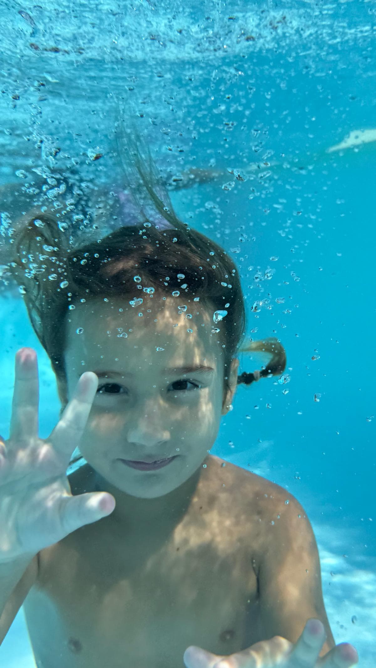 Nen sota l'aigua a la piscina